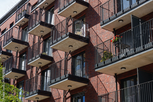 Foto Modern brick apartment building with balconies and metal railings in residential