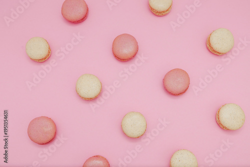 Pink and Vanilla Macarons Evenly Spaced on Light Pink Background