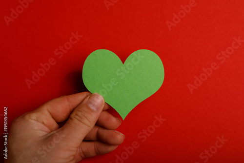 Hand holding a green paper ...