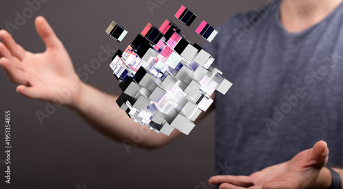Abstract concept of digital technology and human interaction. A man holds a futuristic cube formation, representing dat