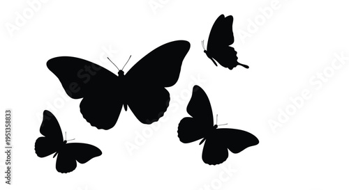 Four butterflies in flight depicted as a stark black silhouette
