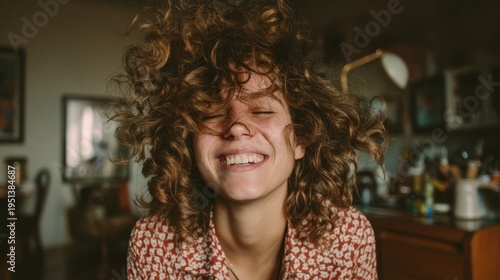 Young woman laughing with tousled hair in living room