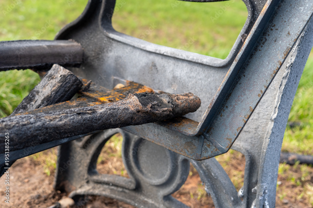 Obraz premium A vandalised burnt bench in a park, UK