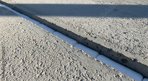 Precision detail of a concrete construction joint featuring modern sealant application and backer rod, essential for infrastructure resilience and structural integrity