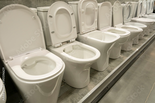 Rows of white toilets lined up in a showroom for customers to view and select for their homes and businesses
