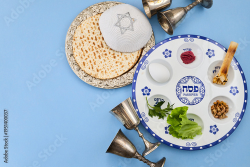 Passover seder plate with matzah, kippah, and silver cups