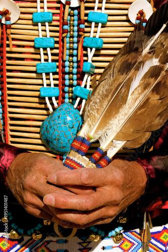 Okhay Owingeh Pueblo, New Mexico, United States. . Native man wearing bone breast plate and holding ceremonial  feathers.