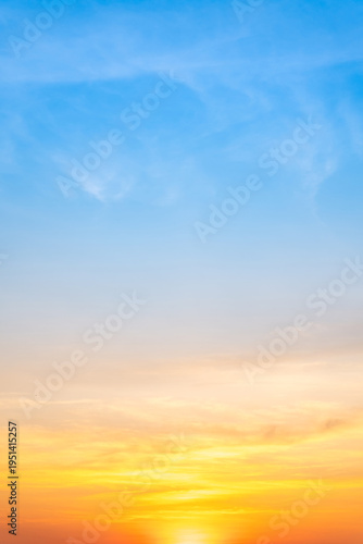 Beautiful sunrise sky with vibrant gradient orange and gold colors and soft blue, Clear atmosphere with wispy clouds. Peaceful, perfect for background and copy space, High resolution images Vertical