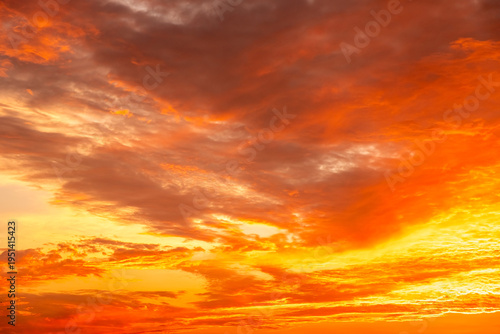Beautiful sunset sky with golden sun rays and clouds. Dramatic orange and blue morning heaven background. Natural sunrise light effect in summer