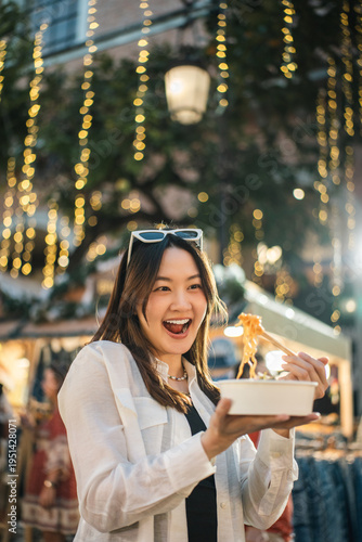 Asian woman enjoy eating street food at night market. Traveler Asian blogger women Happy tourists Beautiful female with Traditional food local road at thailand bangkok city.