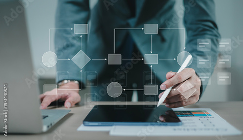 Businessman using stylus pen on digital tablet with workflow automation diagram, data management system, and business process optimization technology concept.