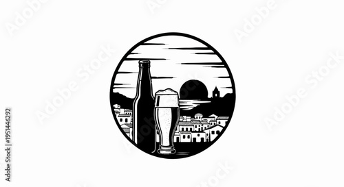 A bottle and glass of beer sit before a coastal town at sunset