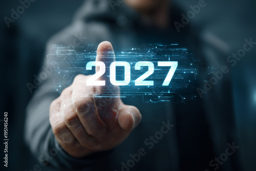 Man finger touching digital glowing 2027 year number on virtual screen, future planning, upcoming trends, and new year goals concept