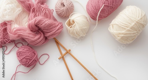 Knitting essentials with pink and white wool yarn on a smooth white background