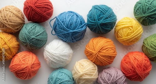 Colorful wool yarn balls arranged on a smooth white backdrop
