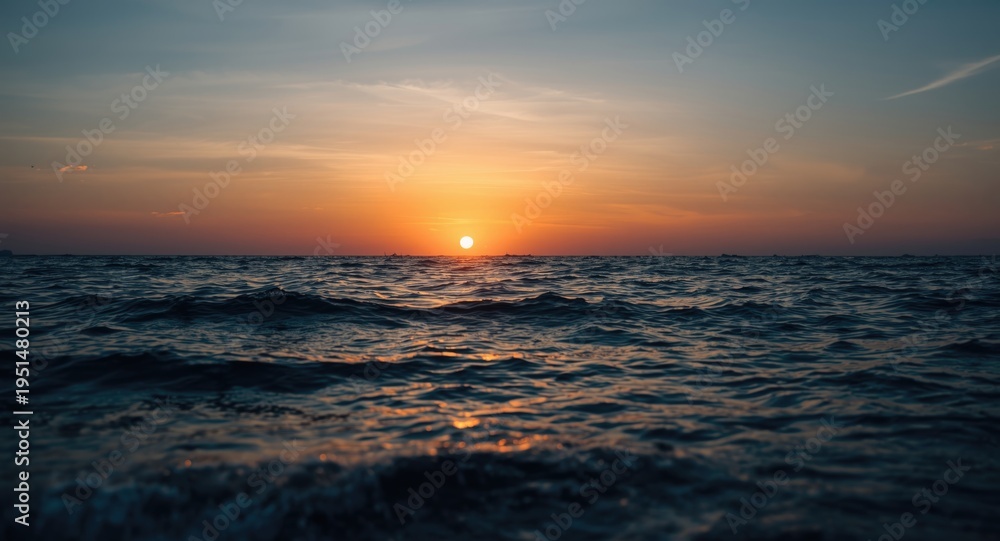 Obraz premium Scenic evening seascape featuring colorful sun setting above tranquil sea waves