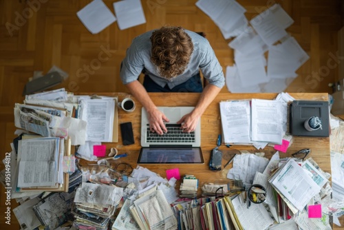 Wallpaper Mural Person working on laptop at messy desk chaotic home office stress productivity concept Torontodigital.ca