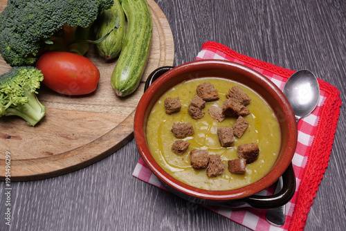 passata di verdure con quadretti di pane tostato , ingredienti sul tagliere, zucchine, cavolo e  pomodoro 