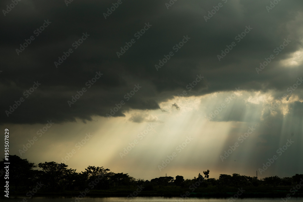 Fototapeta premium Moody Sky with Sun Rays Breaking Through Clouds