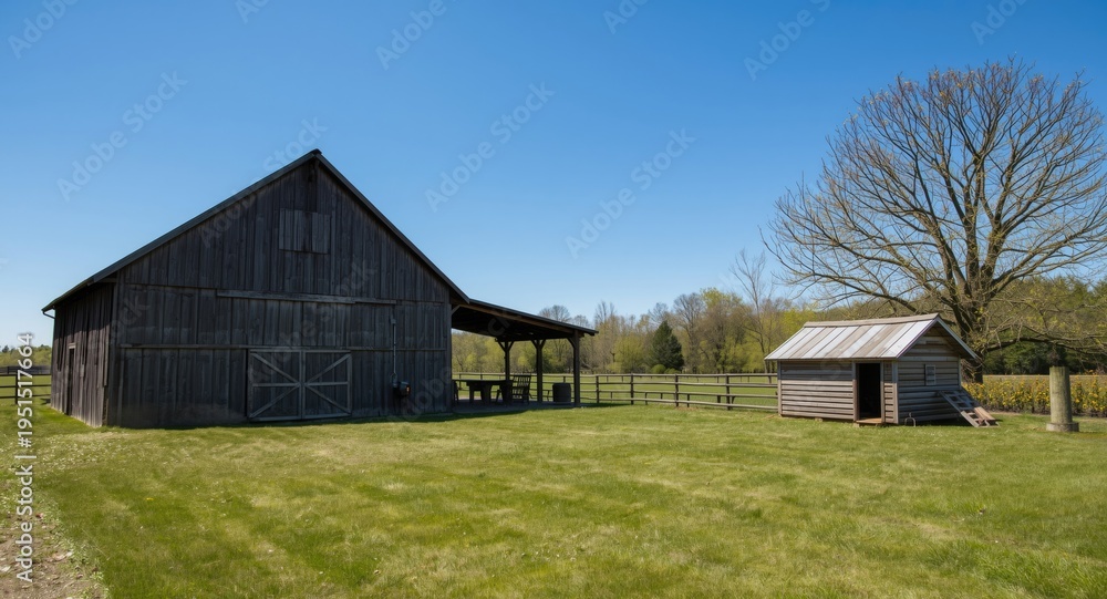 Obraz premium Rustic farmyard scene with wooden barn and chicken coop under a bright blue sky
