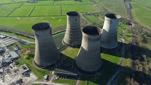 Aerial view of the stark, monumental cooling towers standing in striking contrast to the surrounding verdant fields, a relic of industry against nature's canvas, Retford, United Kingdom.