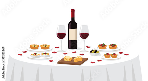 A white table is set with a bottle of red wine, two glasses, cheese, tarts, and rose petals for a romantic dinner.