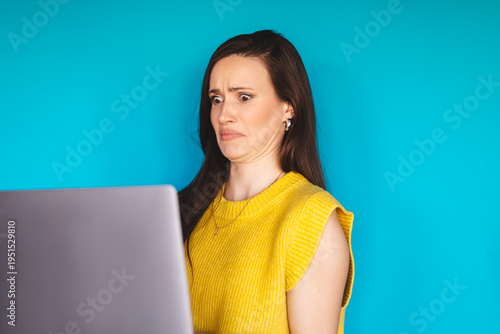 Quadro em tela Disgusted young woman looking at laptop screen with grimace, brunette female mod