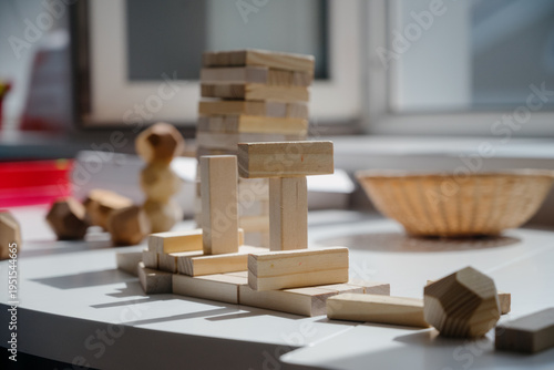 Wooden building blocks arranged on a table with natural light streaming in