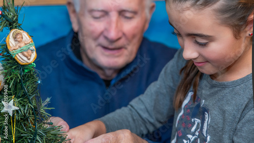 Fotografie An elderly gentleman with his nephew at home decorating Christmas Tree