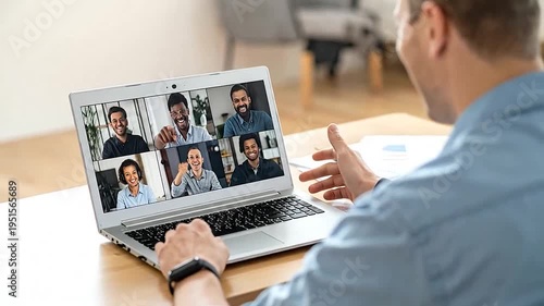 Man participates in a virtual video conference call on his laptop from home