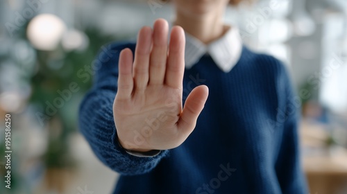 Female human resources manager showing palm of hand in stop gesture at modern office background, concept for workplace harassment prevention, declining proposal and setting boundaries