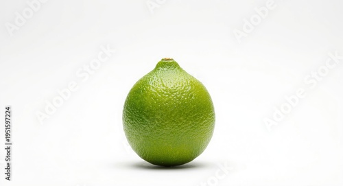 Ripe lime citrus standing alone against a white photography backdrop