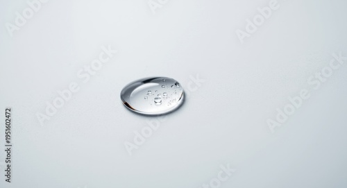 Sharp macro imagery displaying one water droplet resting gently on a white car window surface