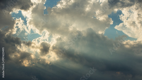 Photography Sun rays streaming through clouds in clear blue sky
