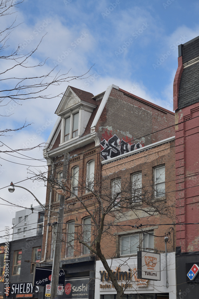 Fototapeta premium historic building facade and commercial signs for Yukimi Donburi (412 Queen W), To-Ne Sushi (414 Queen W), and Shelby's Legendary Shawarma (416 Queen W), Toronto