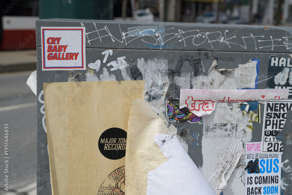 Fototapeta premium Cry Baby Gallery sticker on a grungy Canada Post grungy relay box, Toronto