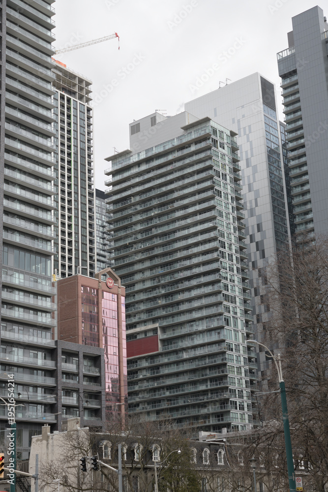 Fototapeta premium looking northeast from Spadina Av near Clarence Square with historic row houses (bottom) and condos incl King's Tower (393 King St W), Toronto