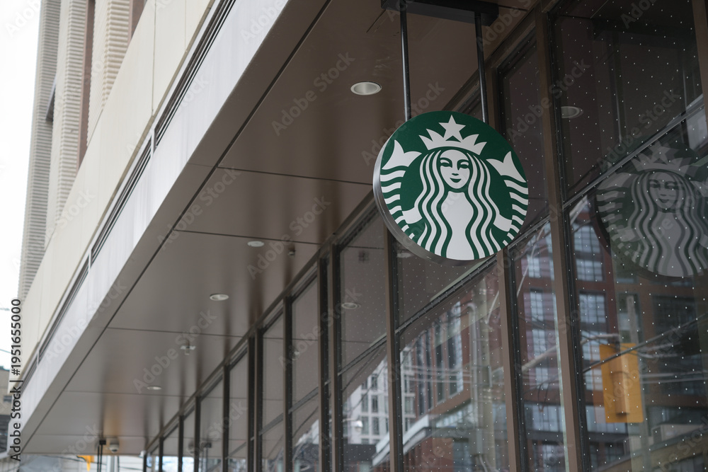 Obraz premium ceiling mounted suspended sign with round Starbucks Coffee Company Mermaid logo outside 123 Portland St, Toronto