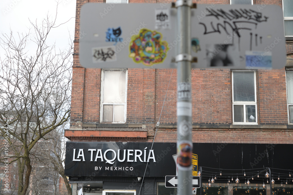 Fototapeta premium abstract view of building facade and sign of La Taqueria by Mexhico (seen from Sullivan St) located at 221 Spadina Av, Toronto