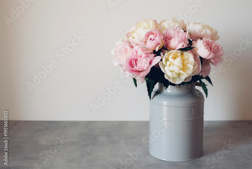 Beautiful bouquet of fresh colorful peonies in full bloom in vase. Floral spring still life. Copy space for text.