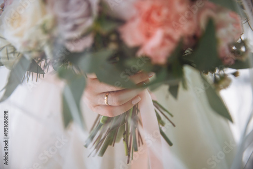 Wedding bouquet under the bride veil. The bride is holding a bouquet
