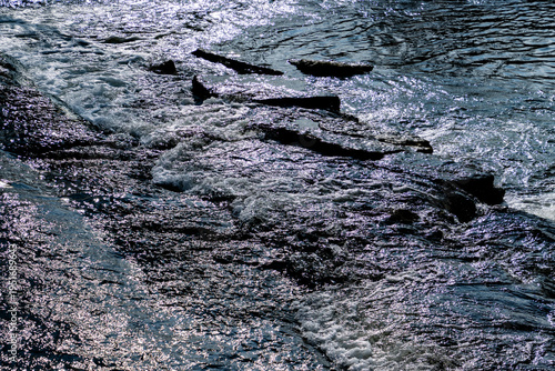 Rushing Water Stream in a Rocky Creek Under Bright Sunlight