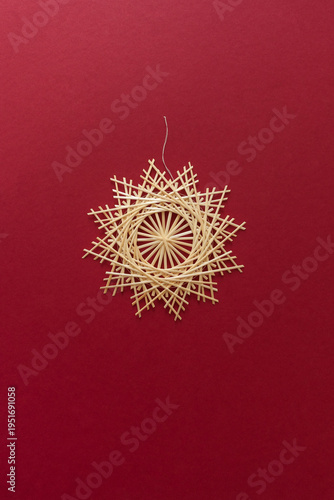 Straw snowflake. Snowflakes are made of straw on a red background. Christmas decor. Top view. Straw weaving. Lutsk, Ukraine
