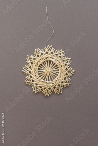 Snowflakes are made of straw on gray background. Straw snowflakes. Christmas decor. Top view. Straw weaving. Lutsk, Ukraine