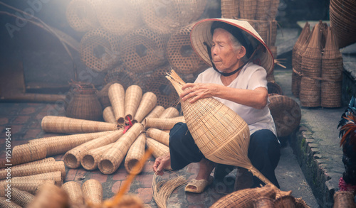 Quadro su tela Vietnamese fishermen are doing basketry for fishing equipment at morning in Thu Sy Village, Vietnam