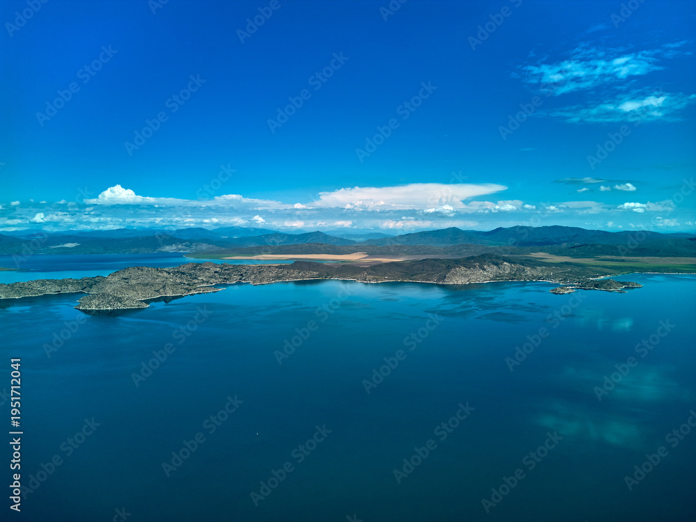 Obraz premium Aerial view of the vast Bukhtarma Reservoir with deep blue water and mountains in Kazakhstan