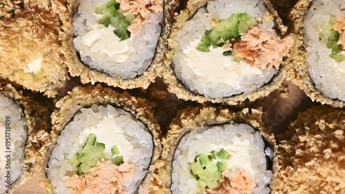 Fried sushi rolls with crispy tempura coating, Japanese food background