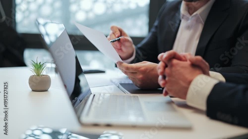Business meeting with two professionals reviewing documents. Focus on serious discussion, planning, and agreement. The atmosphere is calm fostering effective collaboration and decision-making.
