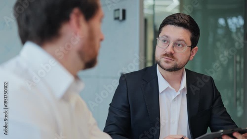 Professional colleagues in serious business discussion. Listener displays focused attention, interest, and understanding of presented strategy. Corporate collaboration showing thoughtful communication