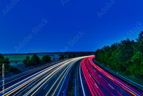 German Autobahn at Sunset with Long Exposure Light Trails and Gantry Sign